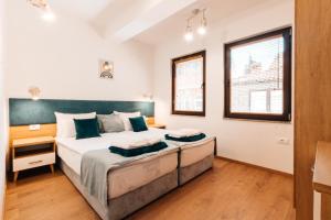 a bedroom with a large bed and two windows at Blue Lake Apartments in Ohrid
