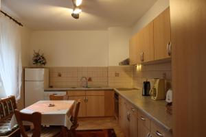 eine Küche mit einem Tisch und einem weißen Kühlschrank in der Unterkunft Haus Marcus in Kolkwitz