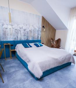 a bedroom with a large bed with blue walls at ZOFIA in Władysławowo