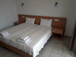 a bedroom with a bed with two towels on it at Plataria Palace in Plataria +51 photos