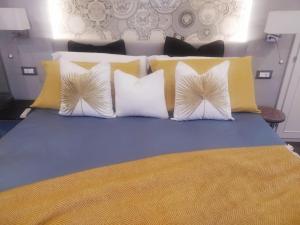 una camera da letto con un letto con cuscini gialli e bianchi di Vernazza Luxury Apartment a Vernazza