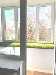 a bathroom with two windows and a white sink at Park Lake Апартаменти Центр in Ternopilʼ