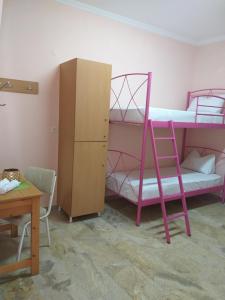 a bedroom with a bunk bed and a desk at Youth hostel Anna in Perissa