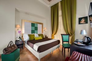 Schlafzimmer mit einem Bett und einem Schreibtisch mit einem Telefon in der Unterkunft DVE Suite Rome in Rom