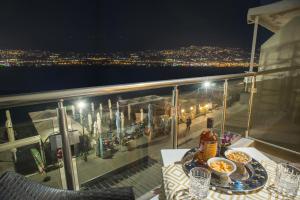 a table with a plate of food on a balcony at night at KSP Studios in Perea