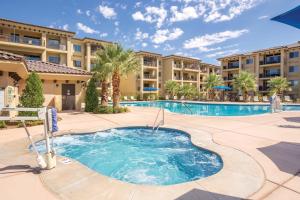 - une piscine avec des palmiers et des immeubles d'appartements dans l'établissement WorldMark Estancia, à Saint George