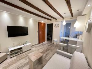 ein Wohnzimmer mit einem Flachbildfernseher an der Wand in der Unterkunft The well in Korfu-Stadt