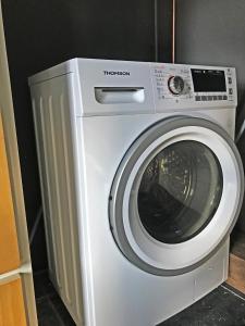 uma máquina de lavar roupa branca sentada num quarto em Waterside House # Opperdoes em Opperdoes