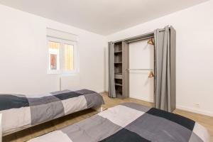 a bedroom with two beds and a window at Le Flamand, jeux en bois déco du nord! in Tourcoing