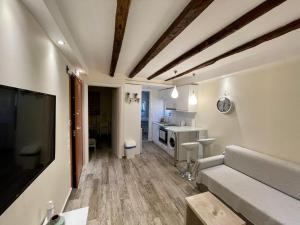 ein Wohnzimmer mit Couch und Fernseher und eine Küche in der Unterkunft The well in Korfu-Stadt + 24 Fotos