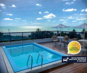 a swimming pool on a deck with a view of the ocean at Littoral Express in João Pessoa
