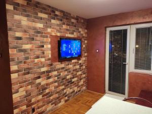 Elle est dotée d'un mur en briques et d'une télévision à écran plat. dans l'établissement Modern cozy apartment, à Niš