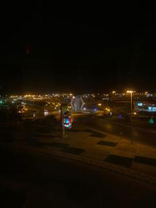 Una vista de una ciudad de noche con luces. en الواحة ان للشقق المخدومة, en Hotat bani tamim