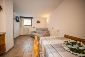 a bedroom with a bed and a chair and a couch at Baita Kate in Livigno