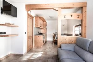 a living room with a couch and a kitchen at Baita Kate in Livigno