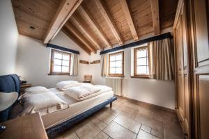 a bedroom with two beds in a room with wooden ceilings at Baita Kate in Livigno