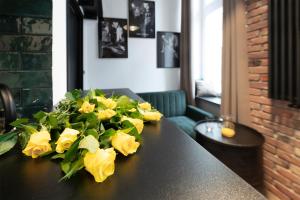 een tafel met gele bloemen erop bij Promised Land - Piotrkowska 37 in Łódź