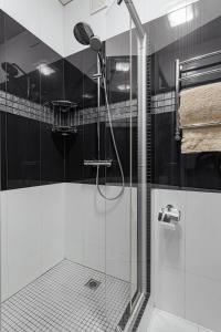 a shower with a glass door in a bathroom at Elegant city center apartment in Odesa