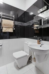 a white bathroom with a toilet and a sink at Elegant city center apartment in Odesa