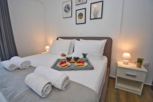 a white bed with a tray of food on it at Potamos Superior Apartment in Potamós