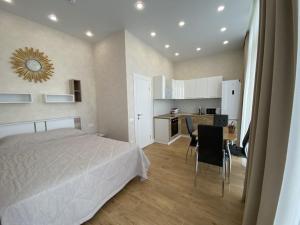 アドレルにあるComfort Olympic Apartmentsのベッドルーム1室(ベッド1台、テーブル付)、キッチン