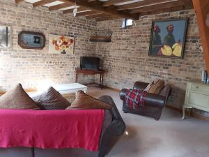 a living room with a couch and a brick wall at The coach house in Llansantffraid-ym-Mechain
