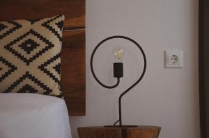 a lamp on a night stand next to a bed at Samothrakis Michelangelo 101 Luxury apartment in Samothraki