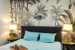 1 dormitorio con 1 cama con almohadas azules y un mural de palmeras en Pretty house Sa Font in Santa Catalina Palma city, en Palma de Mallorca