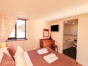 a bedroom with a bed and a bathroom with a tub at Stable Cottage in Wigton