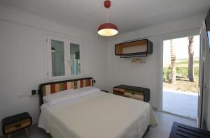 1 dormitorio con cama blanca y ventana en Villa degli Alberi, en Buseto Palizzolo