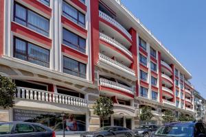 un gran edificio rojo con coches estacionados frente a él en Luxury center apartments in Grand Karavel, en Varna