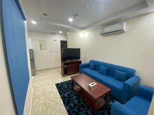 sala de estar con sofá azul y mesa en لحظة الاحلام للشقق الفندقية, en La Meca