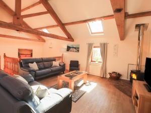 a living room with a couch and a table at Hayloft Cottage in Wigton