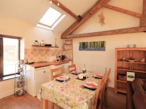 uma cozinha e sala de jantar com mesa e cadeiras em Horseshoe Cottage em Wigton