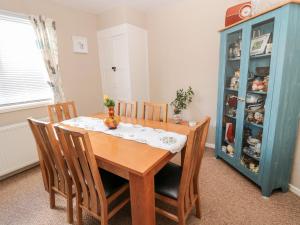 mesa de comedor con sillas y armario azul en Cra-na-ge, en Embleton