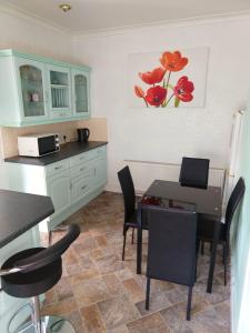 a kitchen with a table and chairs and a kitchen with a counter at Napier Town House - Self Catering - Guesthouse Style - Twin and Double Rooms in Workington