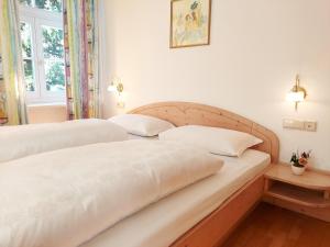 een paar bedden in een slaapkamer met witte muren bij Residence Zum Theater in Colle Isarco