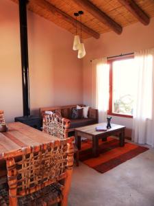 ein Wohnzimmer mit einem Sofa und einem Tisch in der Unterkunft Tierra Quebrada Cabañas in Purmamarca