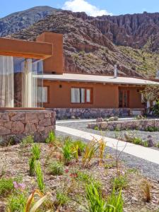 a house with a mountain in the background at Tierra Quebrada Cabañas in Purmamarca