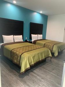 2 camas en una habitación con paredes azules en LOTUS INN en Houston