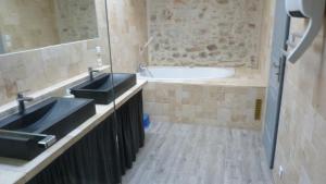 a bathroom with two sinks and a bath tub at La Pause Ardéchoise in Saint-Remèze