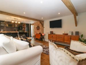 The Courtyard - Hilltop Barn في بلاندفورد فوروم: غرفة معيشة مع أريكة بيضاء وتلفزيون