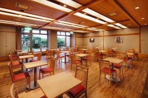 a restaurant with wooden tables and chairs and windows at Hakata Nakasu Washington Hotel Plaza in Fukuoka