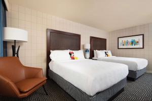 a hotel room with two beds and a chair at Hotel Lulu, BW Premier Collection in Anaheim