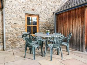 ein Tisch und vier Stühle auf einer Terrasse in der Unterkunft Bugaboo Cottage in Weem