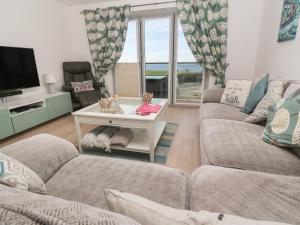 a living room with two couches and a tv at Ocean Seven in Newquay