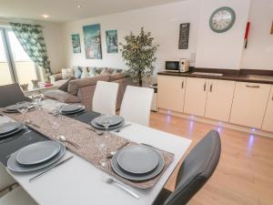 a dining room and living room with a table and chairs at Ocean Seven in Newquay