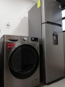 um frigorífico de aço inoxidável e uma máquina de lavar roupa num quarto em NSI Alameda Park Humboldt Mexico City em Cidade do México