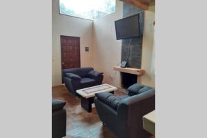 ein Wohnzimmer mit 2 blauen Sofas und einem TV in der Unterkunft Mazamitla - Cabaña Topacio in Mazamitla