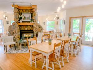 a dining room with tables and a stone fireplace at Inn on Canyon in Radium Hot Springs